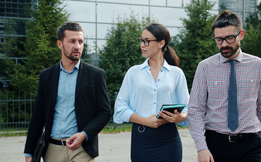 Business professionals walking and discussing in a European city